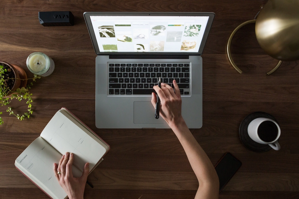 Monthly website support checklist for artists and charities beside a laptop.